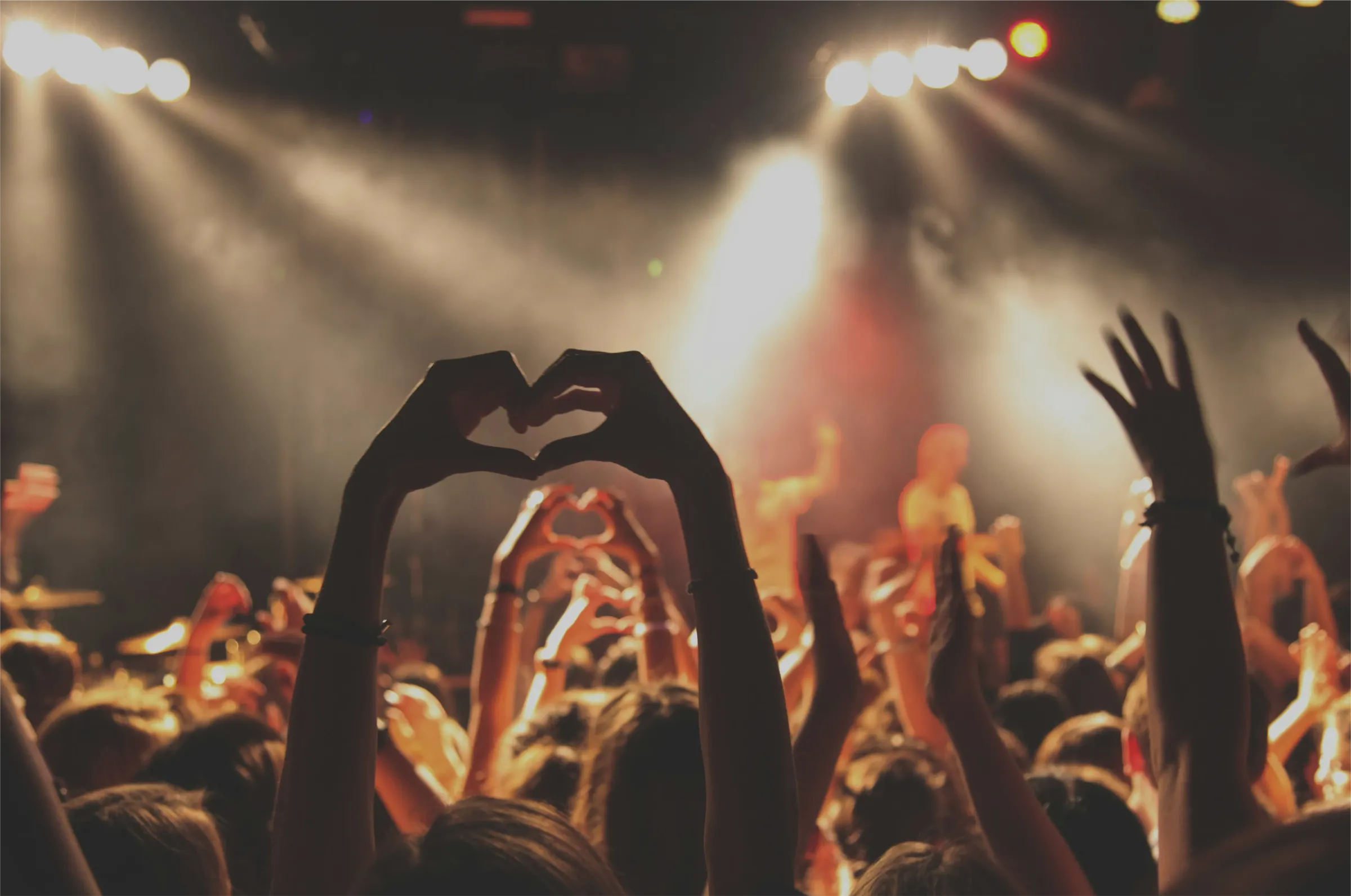 Gente con las manos arriba animando un concierto