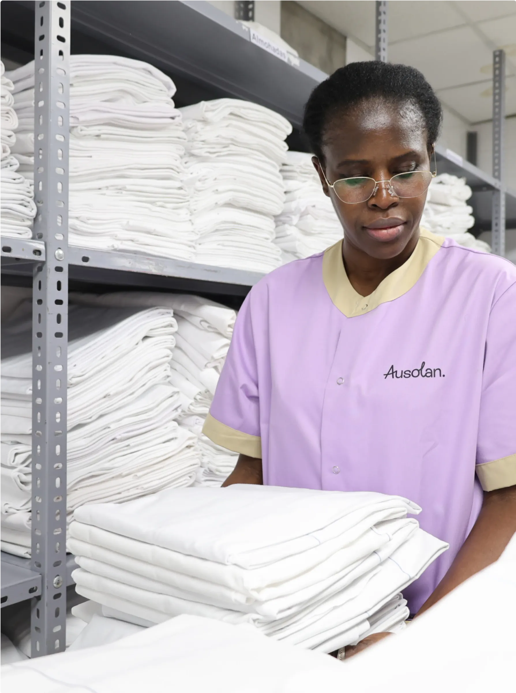 Trabajadora con uniforme de Ausolan llevando toallas