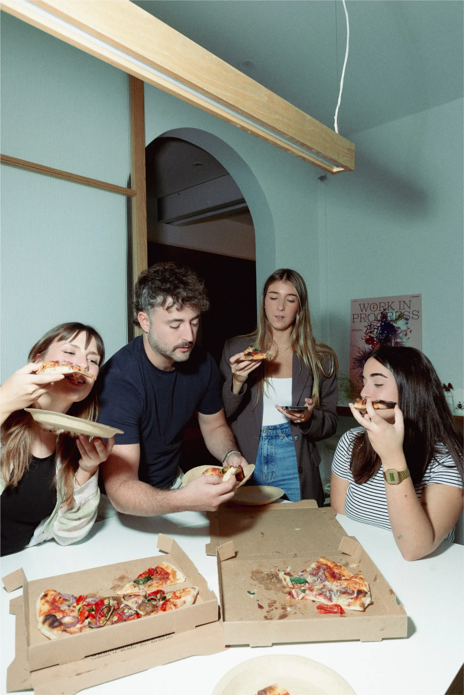 Grupo de personas comiendo pizza con las manos
