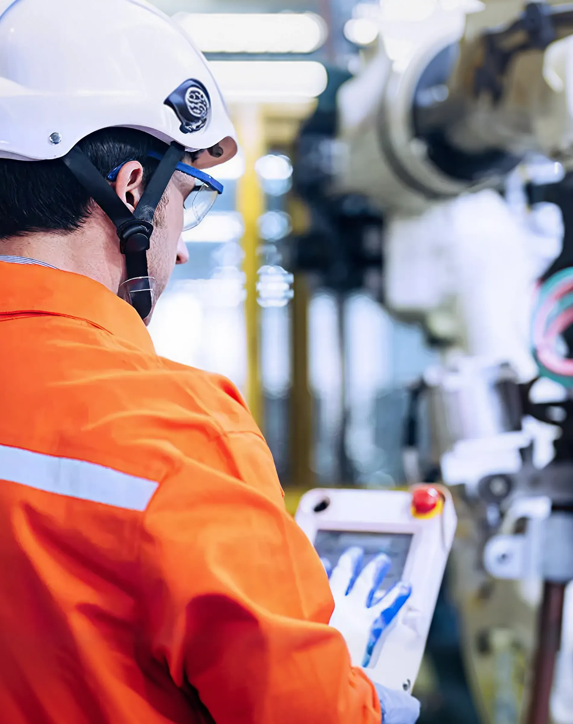 Operario con casco usando una tablet en una fábrica